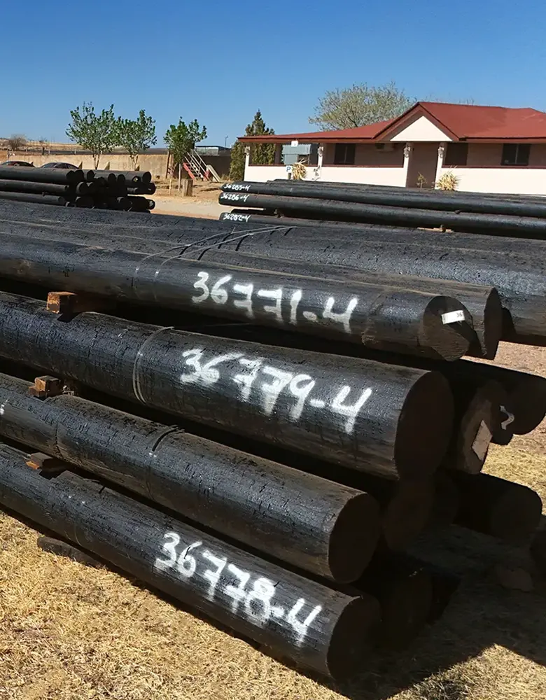 Postes de madera tratada con preservantes industriales, suministrados por GP Prefabricados en alianza con especialistas en impregnación, para máxima durabilidad en campo.